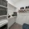 Interior closet space, carpet flooring, ceiling light, built-in shelving