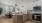 Kitchen with Breakfast bar Counter with cabinet space, ceiling lighting, hardwood flooring, stainless steel appliances