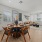 Interior space with dining table, living room, large windows, hardwood flooring