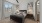 A bedroom with a bed and wall decor, large window, ceiling fan, carpet flooring