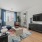Interior living room, hardwood flooring, furnished model, large window, door leading to patio
