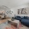 A room with sofa wall decor, hardwood flooring, facing living room and kitchen